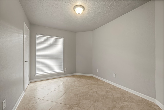 unfurnished room featuring a textured ceiling and light tile patterned floors