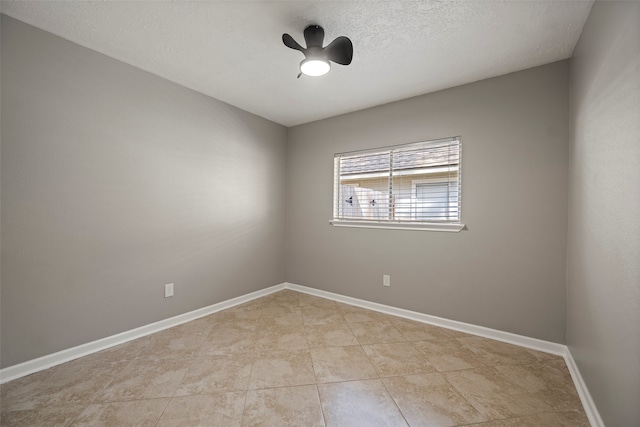 empty room with a textured ceiling, ceiling fan, and light tile patterned flooring