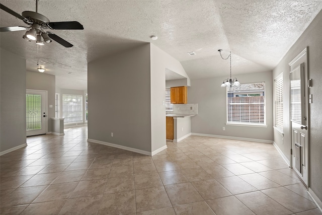 interior space featuring light tile patterned flooring, a textured ceiling, and lofted ceiling