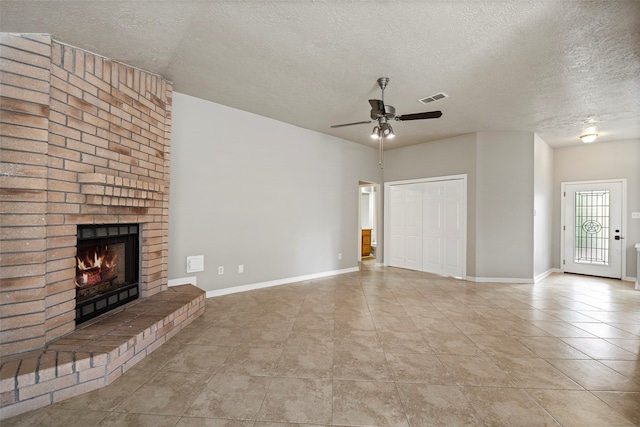 unfurnished living room featuring a textured ceiling, light tile patterned floors, ceiling fan, and a brick fireplace