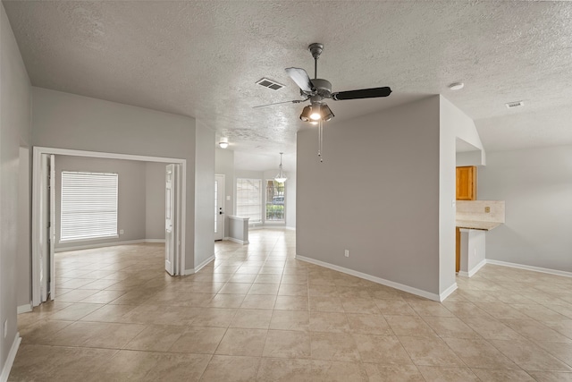 tiled empty room with a textured ceiling, lofted ceiling, and ceiling fan