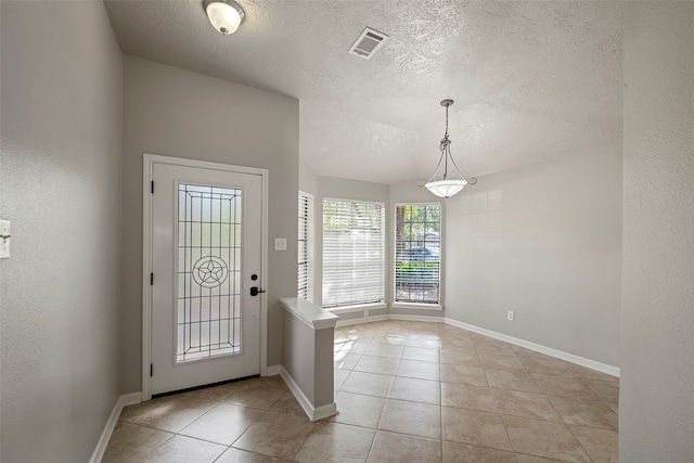 tiled foyer featuring a textured ceiling