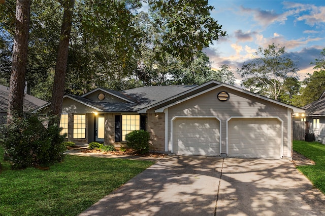 ranch-style house featuring a garage and a yard