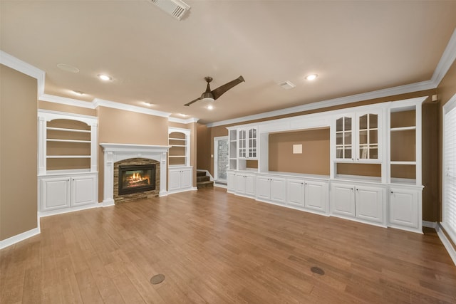 unfurnished living room with a fireplace, light wood-type flooring, and crown molding