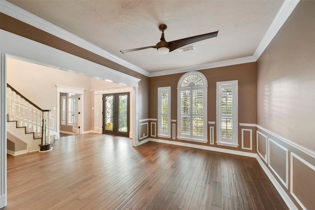 spare room with french doors, hardwood / wood-style flooring, ornamental molding, and a textured ceiling