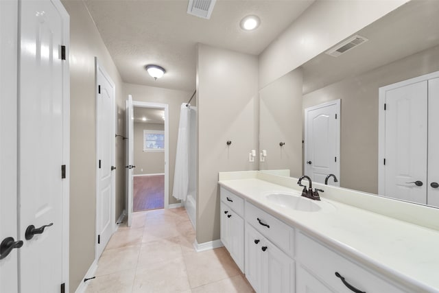 bathroom featuring vanity, a textured ceiling, and tile patterned floors