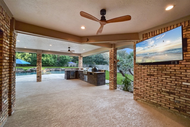 view of patio with area for grilling, ceiling fan, and exterior kitchen