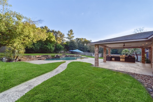 view of yard with a patio area, ceiling fan, and exterior kitchen