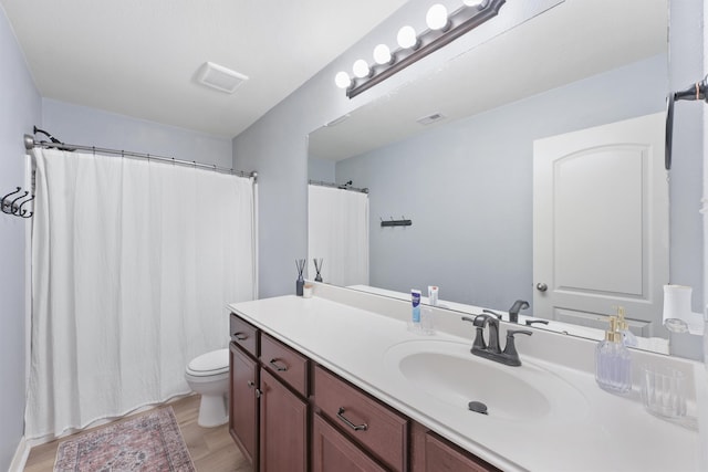 bathroom with vanity, hardwood / wood-style flooring, and toilet