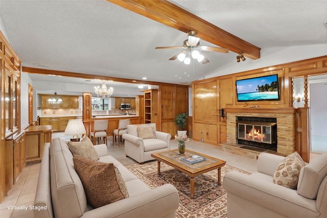 living room featuring lofted ceiling with beams, ceiling fan with notable chandelier, light tile patterned floors, a textured ceiling, and a fireplace