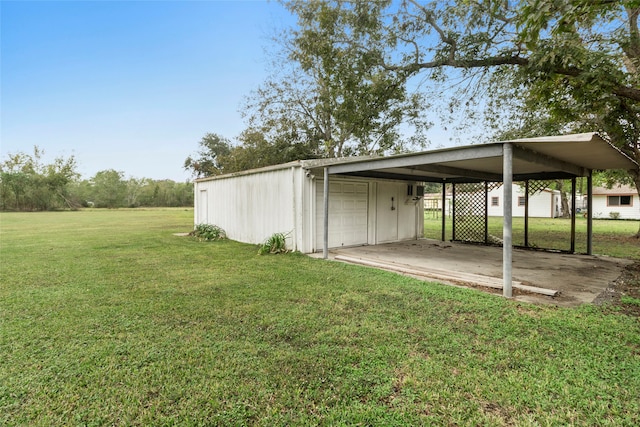 view of yard with a carport, a garage, and an outdoor structure