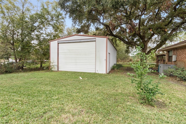 garage featuring central AC unit and a yard