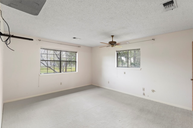 unfurnished room featuring carpet flooring, a textured ceiling, plenty of natural light, and ceiling fan