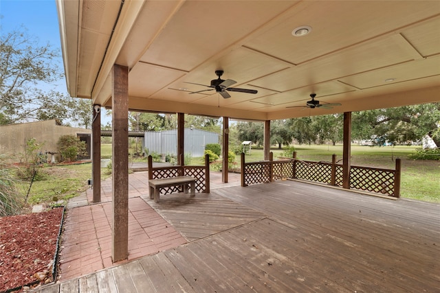 wooden deck with ceiling fan and a lawn