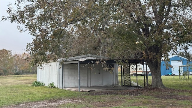 view of outbuilding featuring a yard, a garage, and a carport