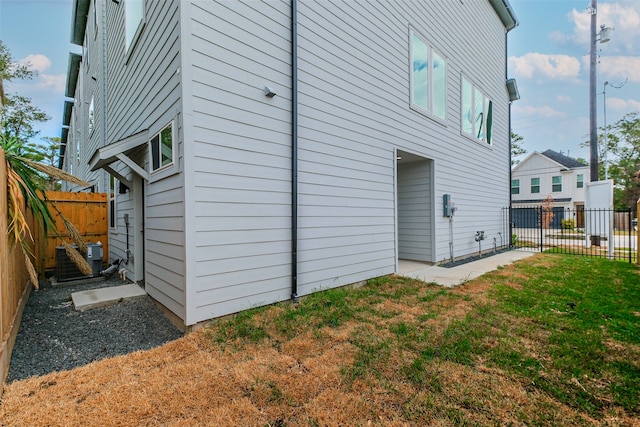 view of side of property featuring central AC and a lawn