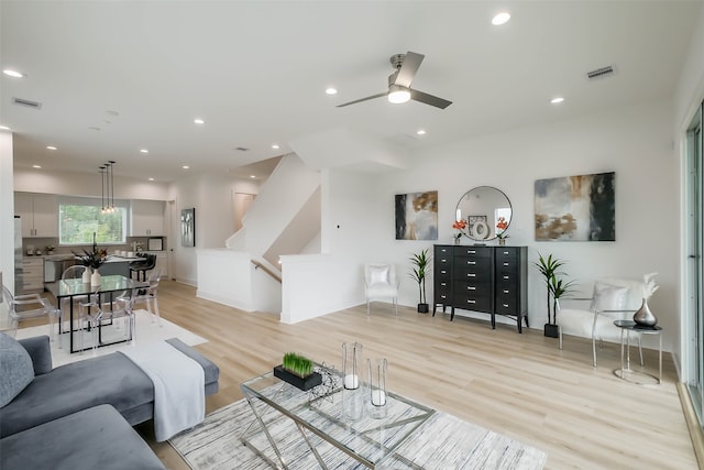 living room featuring light hardwood / wood-style floors and ceiling fan