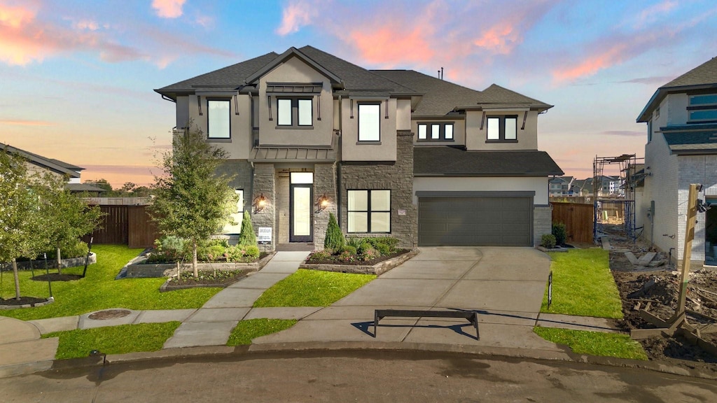 view of front of property featuring a garage and a lawn