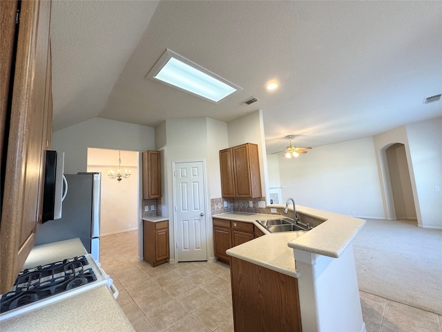 kitchen featuring light tile patterned flooring, sink, decorative backsplash, kitchen peninsula, and vaulted ceiling