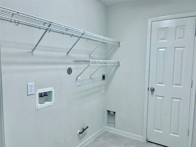 clothes washing area featuring gas dryer hookup, electric dryer hookup, light tile patterned floors, and washer hookup