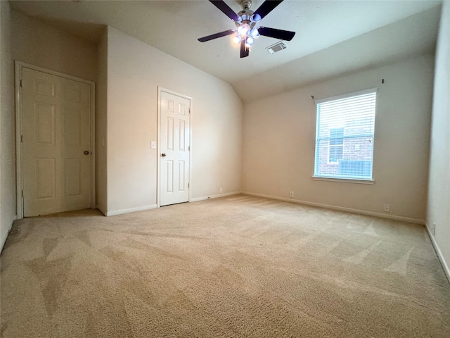 unfurnished bedroom with carpet, visible vents, a ceiling fan, vaulted ceiling, and baseboards