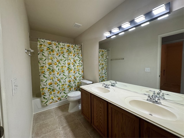 bathroom featuring toilet, tile patterned flooring, double vanity, and a sink