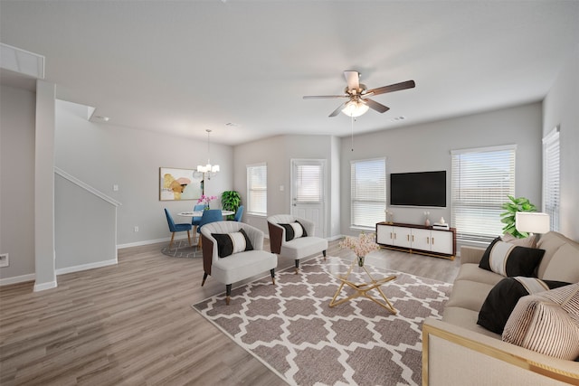 living room with hardwood / wood-style floors and ceiling fan with notable chandelier