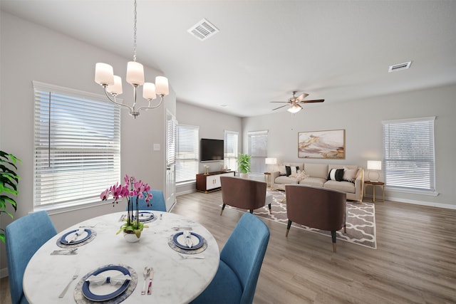 dining area featuring hardwood / wood-style floors and ceiling fan with notable chandelier