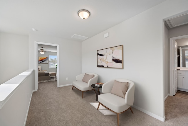 living area with light colored carpet and ceiling fan