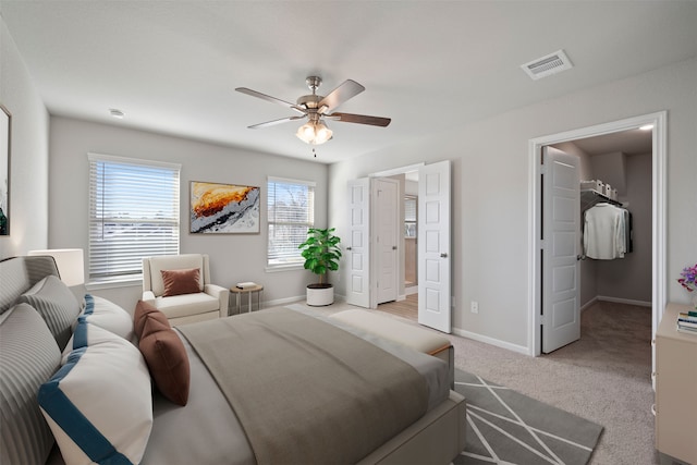 carpeted bedroom featuring a spacious closet and ceiling fan