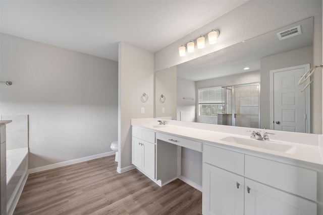 full bathroom featuring wood-type flooring, independent shower and bath, toilet, and vanity