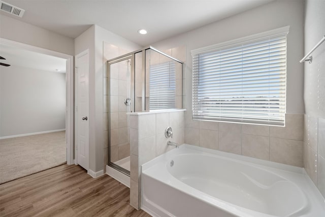 509 Emerald Thicket Trl, Huffman, TX 77336 - bathroom featuring a stall shower, a garden tub, wood finished floors, recessed lighting, and baseboards
