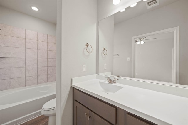 511 Emerald Thicket Ln, Huffman, TX 77336 - bathroom featuring toilet, wood finished floors, vanity, a ceiling fan, and shower / washtub combination