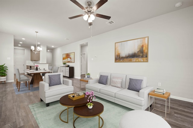 living room with hardwood / wood-style floors and ceiling fan with notable chandelier