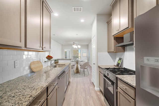 511 Emerald Thicket Ln, Huffman, TX 77336 - kitchen with stainless steel appliances, a sink, light wood finished floors, wall chimney exhaust hood, and recessed lighting