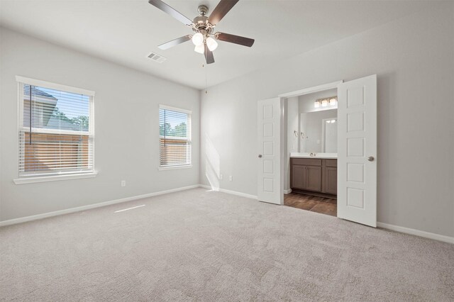 511 Emerald Thicket Ln, Huffman, TX 77336 - unfurnished bedroom with carpet floors, baseboards, ensuite bathroom, and a ceiling fan