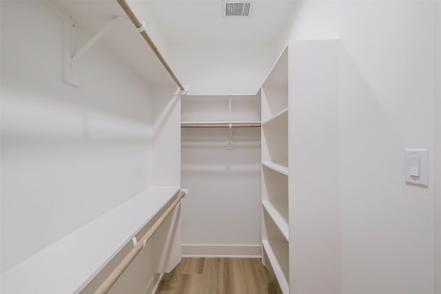 walk in closet with light wood-type flooring