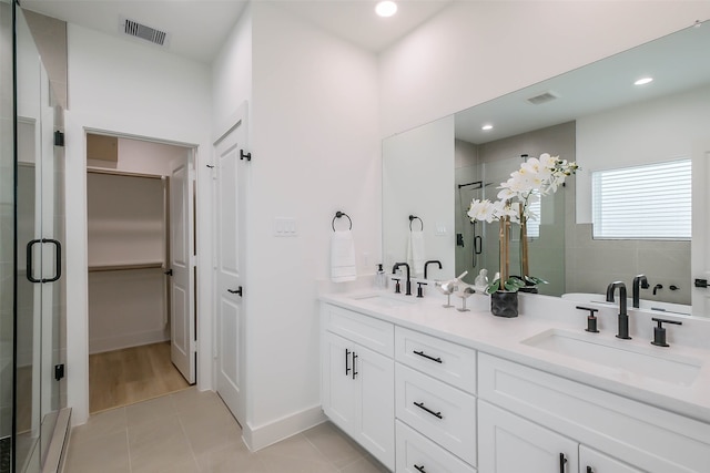 bathroom with vanity, a shower with door, and tile patterned flooring