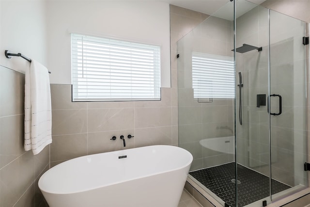 bathroom featuring tile walls, baseboard heating, and shower with separate bathtub