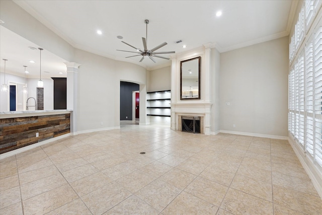 unfurnished living room featuring ceiling fan, ornamental molding, and light tile patterned flooring