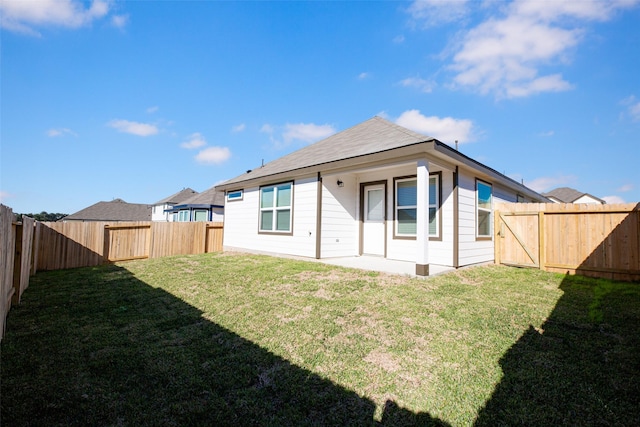 rear view of property featuring a patio area and a yard