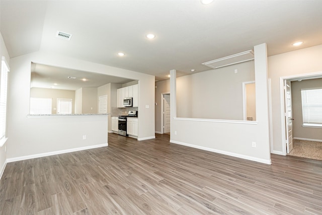 unfurnished living room featuring light hardwood / wood-style floors and lofted ceiling