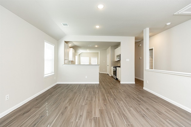 unfurnished living room with light hardwood / wood-style flooring and lofted ceiling