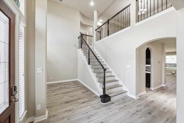 foyer with a towering ceiling and light hardwood / wood-style flooring