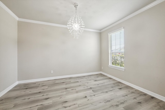 empty room featuring a chandelier, light hardwood / wood-style floors, and crown molding