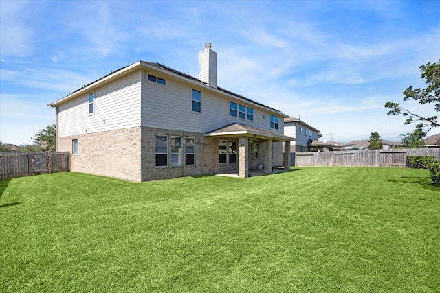 rear view of house featuring a patio and a yard