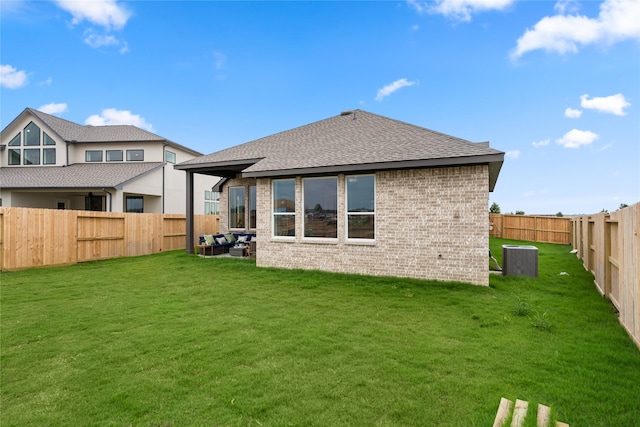 back of property with a lawn and cooling unit