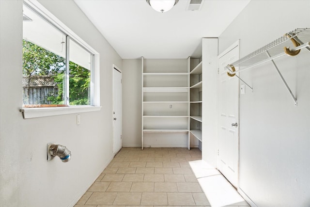 walk in closet with light tile patterned floors