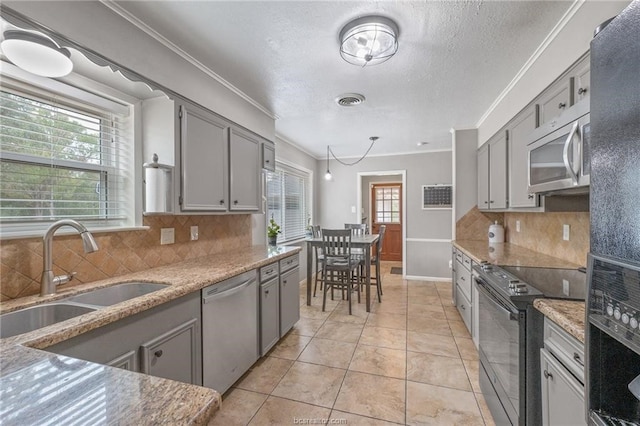 kitchen with tasteful backsplash, appliances with stainless steel finishes, sink, and a healthy amount of sunlight