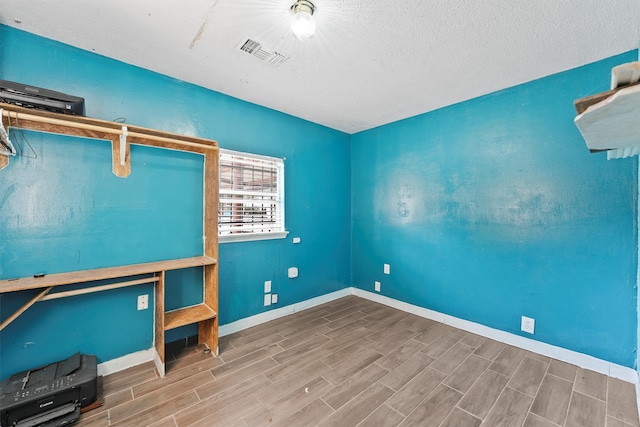 unfurnished office featuring a textured ceiling and hardwood / wood-style flooring